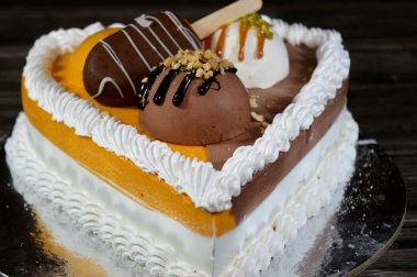 Dondurma ve çeşitli aromalı dondurmalar. Dondurma ve krema içinde kek katmanı olan çeşitli tatlar. Üzerinde karamel sosu olan mango, vanilya ve çikolata.