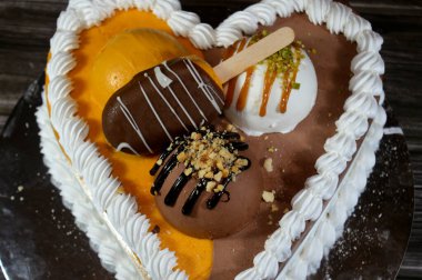 Dondurma ve çeşitli aromalı dondurmalar. Dondurma ve krema içinde kek katmanı olan çeşitli tatlar. Üzerinde karamel sosu olan mango, vanilya ve çikolata.