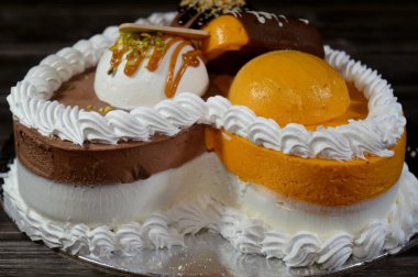 Dondurma ve çeşitli aromalı dondurmalar. Dondurma ve krema içinde kek katmanı olan çeşitli tatlar. Üzerinde karamel sosu olan mango, vanilya ve çikolata.