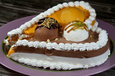 Dondurma ve çeşitli aromalı dondurmalar. Dondurma ve krema içinde kek katmanı olan çeşitli tatlar. Üzerinde karamel sosu olan mango, vanilya ve çikolata.