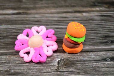 Hamburger sandviçi şekilleri ve kuru hava kilinden yapılan çiçekler çocuklar için eğlenceli parçalar, yaratıcı sanat renkli sanatlar, eğitici, oyun ve çocukların yaratıcılığı, çocuklar için hamur oynamak.