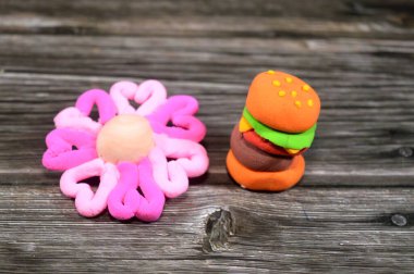 Hamburger sandviçi şekilleri ve kuru hava kilinden yapılan çiçekler çocuklar için eğlenceli parçalar, yaratıcı sanat renkli sanatlar, eğitici, oyun ve çocukların yaratıcılığı, çocuklar için hamur oynamak.