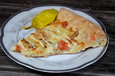 Dilimlenmiş tavuk parçaları, mozzarella peyniri, zeytinyağı, taze otlar, çiftlik sosu, domates sosu, İtalyan mutfağı pizzası, seçici odak noktası.