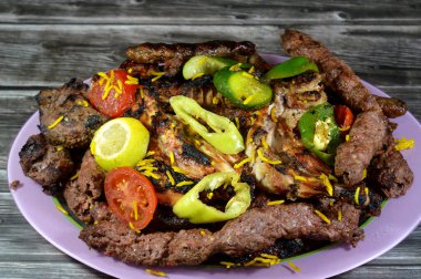 Arap mutfağının bir karışımı geleneksel yemek kömürü ızgara sığır kebabı et parçaları, sosis, Kofta bifteği, Kufta şiş, ızgara tavuk, domates, salatalık ve biber dilimleri.