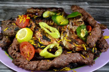 Arap mutfağının bir karışımı geleneksel yemek kömürü ızgara sığır kebabı et parçaları, sosis, Kofta bifteği, Kufta şiş, ızgara tavuk, domates, salatalık ve biber dilimleri.