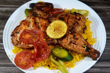 Kömür ızgarasında ızgara tavuk, ızgara Arap yemeği, Sarı Basmati Hint pilavı, domates, salatalık, limon ve biber dilimleri.