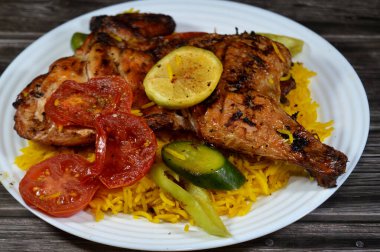 Kömür ızgarasında ızgara tavuk, ızgara Arap yemeği, Sarı Basmati Hint pilavı, domates, salatalık, limon ve biber dilimleri.