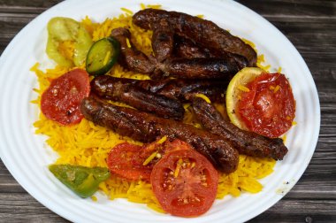 Orta Doğu usulü ızgara sığır eti sosisi ızgara kömür, ızgara Arap yemeği, Sarı Basmati Hint uzun tahıl pilavı, domates, salatalık, limon ve biber dilimleri.