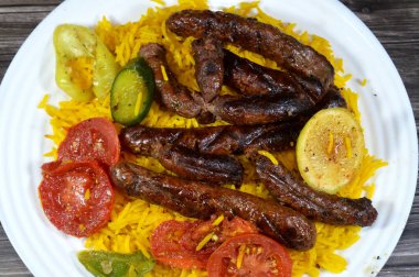 Orta Doğu usulü ızgara sığır eti sosisi ızgara kömür, ızgara Arap yemeği, Sarı Basmati Hint uzun tahıl pilavı, domates, salatalık, limon ve biber dilimleri.