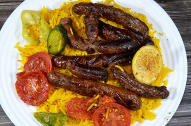 Orta Doğu usulü ızgara sığır eti sosisi ızgara kömür, ızgara Arap yemeği, Sarı Basmati Hint uzun tahıl pilavı, domates, salatalık, limon ve biber dilimleri.