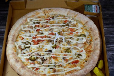 Kahire, Mısır, Nisan, 12025: Papa John 's Jalapeno Tavuk pizzası dilimlenmiş tavuk parçaları, mozarella peyniri, zeytin yağı, taze otlar, acı biber dilimleri, domates sosu, İtalyan mutfağı pizzası