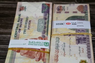 Kahire, Mısır, 17 Nisan 2025: NBE Mısır Ulusal Bankası ve HSBC banknotları Mısır Yığınları üzerine bağlayıcı bant para binlerce pound döviz banknotları 200 EGP LE, Mısır para döviz kuru