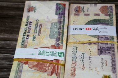 Kahire, Mısır, 17 Nisan 2025: NBE Mısır Ulusal Bankası ve HSBC banknotları Mısır Yığınları üzerine bağlayıcı bant para binlerce pound döviz banknotları 200 EGP LE, Mısır para döviz kuru