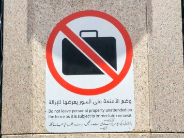 Arapça ve yabancı dilin çevirisi, (Çitin hemen kaldırılmasına tabi olduğu için kişisel mülkiyetinizi sahipsiz bırakmayın) peygamberin Madinah şehrindeki camisinin yanında bir işaret.