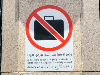 Arapça ve yabancı dilin çevirisi, (Çitin hemen kaldırılmasına tabi olduğu için kişisel mülkiyetinizi sahipsiz bırakmayın) peygamberin Madinah şehrindeki camisinin yanında bir işaret.