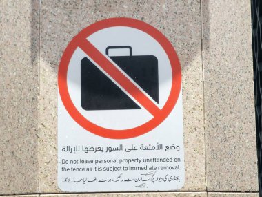 Arapça ve yabancı dilin çevirisi, (Çitin hemen kaldırılmasına tabi olduğu için kişisel mülkiyetinizi sahipsiz bırakmayın) peygamberin Madinah şehrindeki camisinin yanında bir işaret.