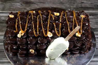 Dondurmalı pasta, vanilyalı dondurma. İçi kek katmanı, çikolatalı ve kremalı, fındıklı ve karamel soslu. Yaz konsepti, vanilyalı ve çikolatalı pasta.