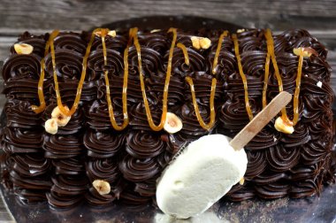 Dondurmalı pasta, vanilyalı dondurma. İçi kek katmanı, çikolatalı ve kremalı, fındıklı ve karamel soslu. Yaz konsepti, vanilyalı ve çikolatalı pasta.