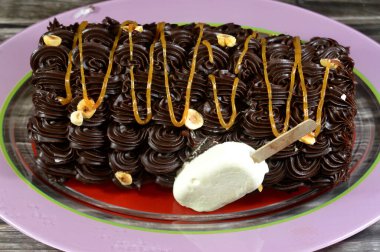 Dondurmalı pasta, vanilyalı dondurma. İçi kek katmanı, çikolatalı ve kremalı, fındıklı ve karamel soslu. Yaz konsepti, vanilyalı ve çikolatalı pasta.