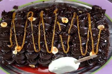 Dondurmalı pasta, vanilyalı dondurma. İçi kek katmanı, çikolatalı ve kremalı, fındıklı ve karamel soslu. Yaz konsepti, vanilyalı ve çikolatalı pasta.