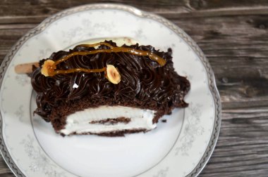 Dondurmalı pasta, vanilyalı dondurma. İçi kek katmanı, çikolatalı ve kremalı, fındıklı ve karamel soslu. Yaz konsepti, vanilyalı ve çikolatalı pasta.