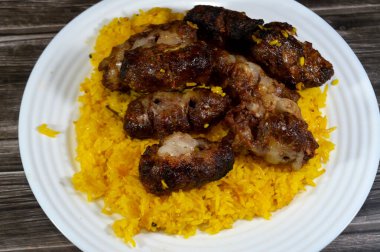 Geleneksel yemek bifteği Kofta, kebap ve tarb kufta kuzu yağına bulanmış et ızgarada kızartılmış ve ızgara Arap yemeği ile servis edilmiş sarı Basmati Hint pilavı.