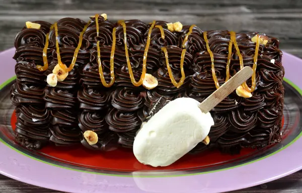 Dondurmalı pasta, vanilyalı dondurma. İçi kek katmanı, çikolatalı ve kremalı, fındıklı ve karamel soslu. Yaz konsepti, vanilyalı ve çikolatalı pasta.