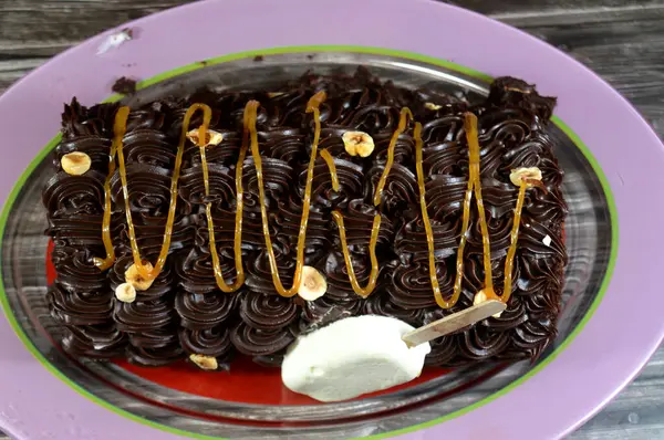 Dondurmalı pasta, vanilyalı dondurma. İçi kek katmanı, çikolatalı ve kremalı, fındıklı ve karamel soslu. Yaz konsepti, vanilyalı ve çikolatalı pasta.