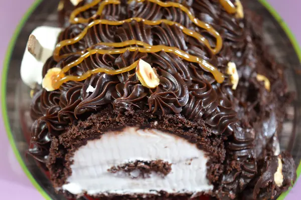 Dondurmalı pasta, vanilyalı dondurma. İçi kek katmanı, çikolatalı ve kremalı, fındıklı ve karamel soslu. Yaz konsepti, vanilyalı ve çikolatalı pasta.