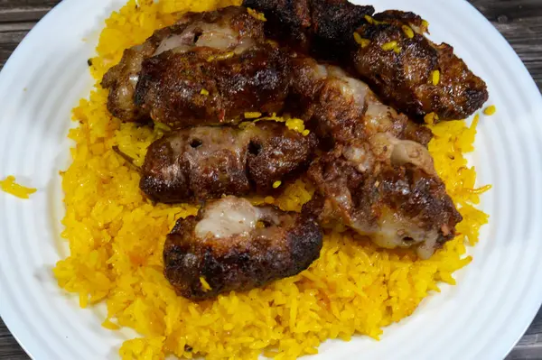 Geleneksel yemek bifteği Kofta, kebap ve tarb kufta kuzu yağına bulanmış et ızgarada kızartılmış ve ızgara Arap yemeği ile servis edilmiş sarı Basmati Hint pilavı.