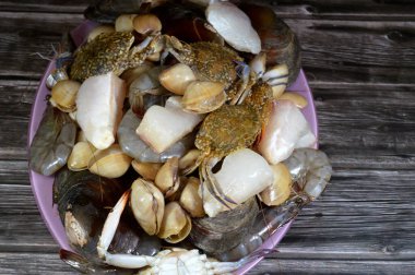 Çeşitli çiğ karides, midye, taze yengeç, balık filetosu ve midye çeşitleri, çeşitli mutfaklarda kullanılabilecek çeşitli deniz ürünleri, balık parçaları, midye, karides ve yengeç.