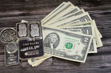 Kahire, Mısır, 16 Mayıs 2025: Amerikan dolar nakit para banknotları ve Nagm Ad-Din saf gümüş külçeler, gümüş yatırım, döviz kuru, enflasyon krizi ve para tasarrufu varlık kavramı