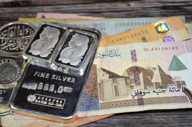 Kahire, Mısır, 16 Mayıs 2025: Sudanlılar para banknotlarını ve Nagm Ad-Din 'i saf gümüş külçeler, gümüş yatırımları, döviz kuru, enflasyon krizi ve para tasarrufu varlıkları kavramını sarstı