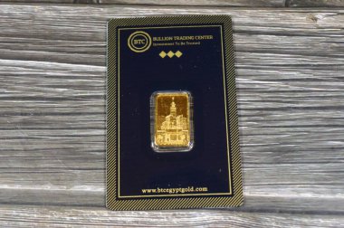 Kahire, Mısır, 16 Mayıs 2025: Makkah saat kuleleri 24 bin karat BTC Bullion Ticaret Merkezi saf sarı altın külçeler, altın yatırımı, döviz kuru, enflasyon krizi ve tasarruf kavramı