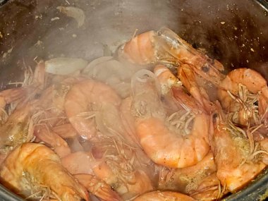 Sıcak buharda soyulmamış gri karidesleri pişirmek ve soğan dilimleri, sarımsaklı kimyon dilimleri, renkli dolma biber dilimleri, pişirilmiş ve ızgara yapılmış tuz, karides kabuklu deniz ürünleri mutfağı.