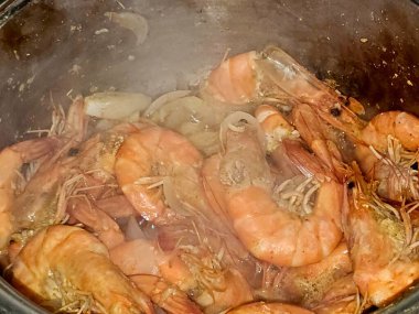 Sıcak buharda soyulmamış gri karidesleri pişirmek ve soğan dilimleri, sarımsaklı kimyon dilimleri, renkli dolma biber dilimleri, pişirilmiş ve ızgara yapılmış tuz, karides kabuklu deniz ürünleri mutfağı.