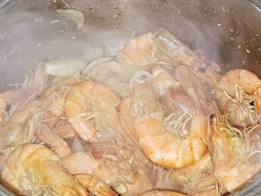 Sıcak buharda soyulmamış gri karidesleri pişirmek ve soğan dilimleri, sarımsaklı kimyon dilimleri, renkli dolma biber dilimleri, pişirilmiş ve ızgara yapılmış tuz, karides kabuklu deniz ürünleri mutfağı.