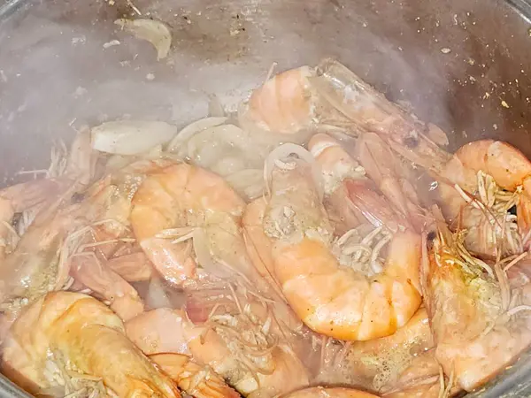 Sıcak buharda soyulmamış gri karidesleri pişirmek ve soğan dilimleri, sarımsaklı kimyon dilimleri, renkli dolma biber dilimleri, pişirilmiş ve ızgara yapılmış tuz, karides kabuklu deniz ürünleri mutfağı.