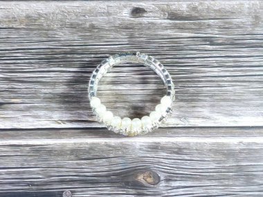 Beyaz inci bilezik, bilekliğe takılan ve kadınlar için dekorasyon ve moda için kullanılan bir takı ya da aksesuardır.