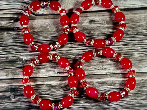 Kırmızı boncuklu kırmızı boncuklu bilezikler, bilekliğe takılan ve kadınlar için dekorasyon ve moda için kullanılan bir takı ya da aksesuar malzemesidir.