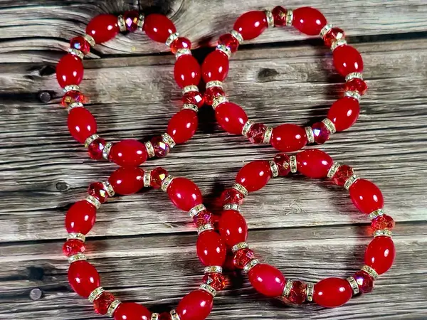 Kırmızı boncuklu kırmızı boncuklu bilezikler, bilekliğe takılan ve kadınlar için dekorasyon ve moda için kullanılan bir takı ya da aksesuar malzemesidir.