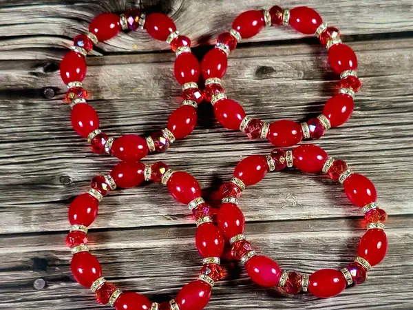 Kırmızı boncuklu kırmızı boncuklu bilezikler, bilekliğe takılan ve kadınlar için dekorasyon ve moda için kullanılan bir takı ya da aksesuar malzemesidir.