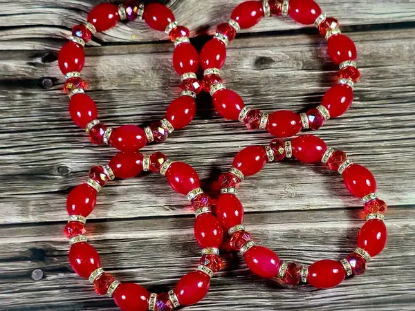 Kırmızı boncuklu kırmızı boncuklu bilezikler, bilekliğe takılan ve kadınlar için dekorasyon ve moda için kullanılan bir takı ya da aksesuar malzemesidir.