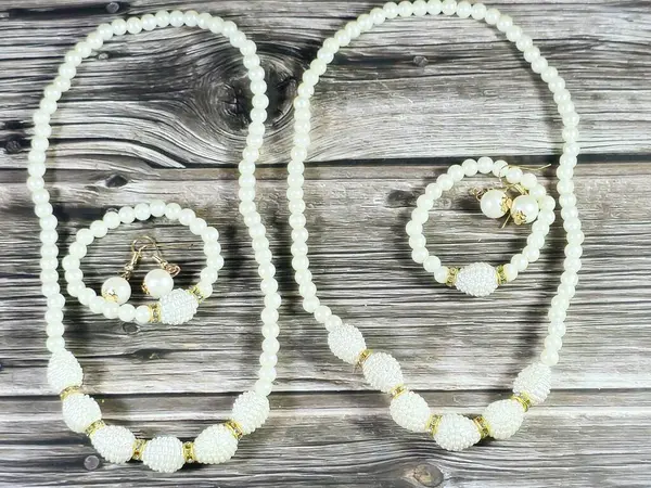 Boncuklu bilezikler, inci küpeler, beyaz boncuk kolye, kadın dekorasyonu ve aksesuar konsepti.