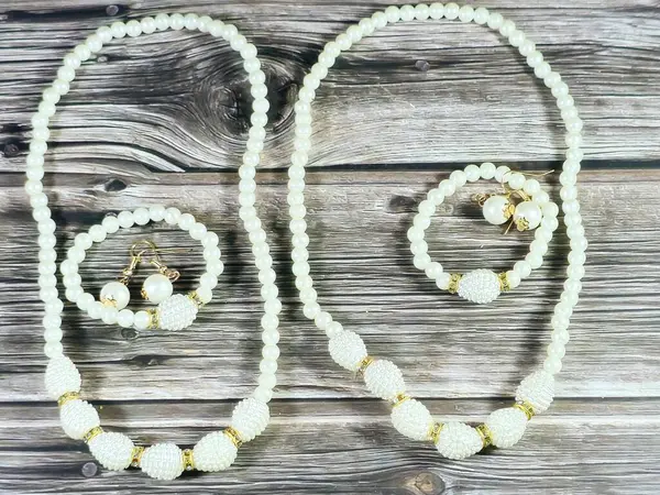 Boncuklu bilezikler, inci küpeler, beyaz boncuk kolye, kadın dekorasyonu ve aksesuar konsepti.