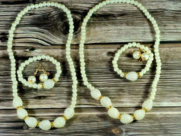 Boncuklu bilezikler, inci küpeler, beyaz boncuk kolye, kadın dekorasyonu ve aksesuar konsepti.