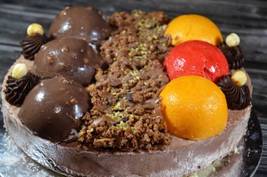 Dondurmalı pasta, üzerinde çikolata topu ve krema, karamel sosu, fındıklı çikolata parçaları, fındık, mango ve çilek topları, yaz ve tatil konsepti.