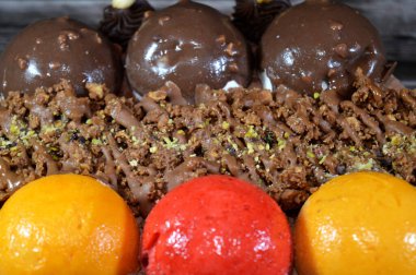 Dondurmalı pasta, üzerinde çikolata topu ve krema, karamel sosu, fındıklı çikolata parçaları, fındık, mango ve çilek topları, yaz ve tatil konsepti.