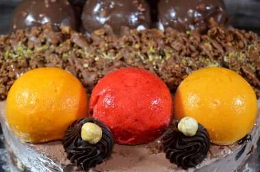 Dondurmalı pasta, üzerinde çikolata topu ve krema, karamel sosu, fındıklı çikolata parçaları, fındık, mango ve çilek topları, yaz ve tatil konsepti.
