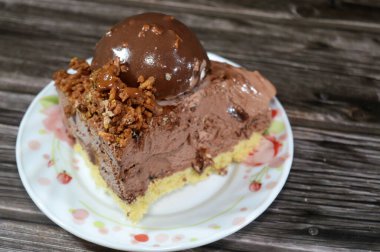 Çikolata topağı ve kremayla kaplı, bir parça dondurmalı pastadan bir parça, ve karamel sosu ve fındıklı çikolata, yaz ve tatil konsepti.